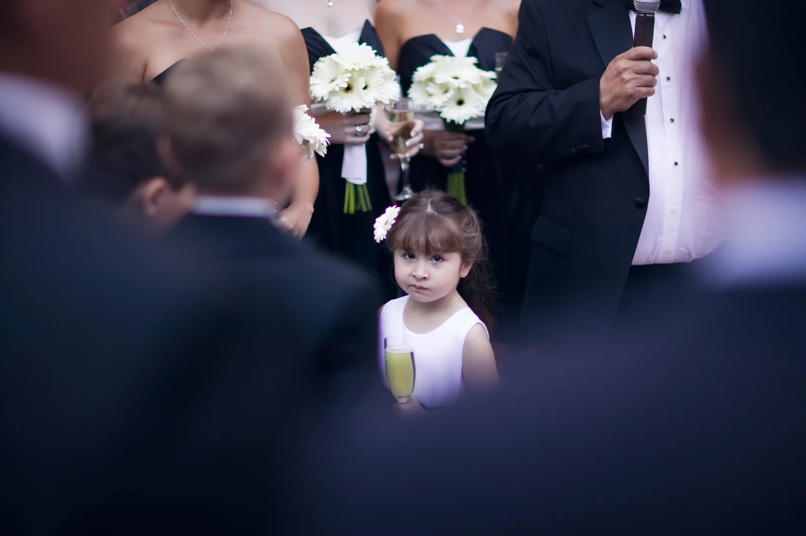 A young wedding guest looking between the adults around her